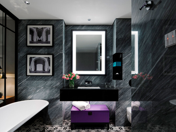 bathroom with tub and marble walls